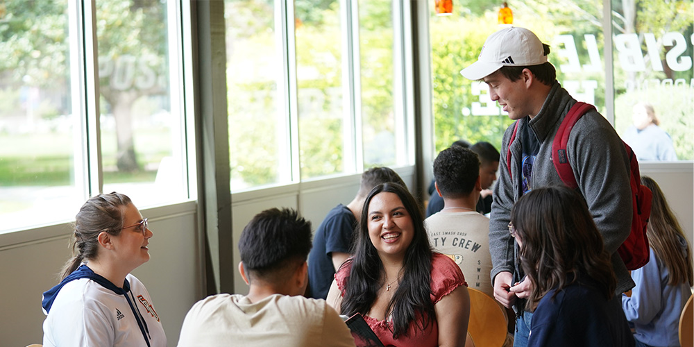 Fresno Pacific University students talk and laugh together at Charlotte’s on campus.