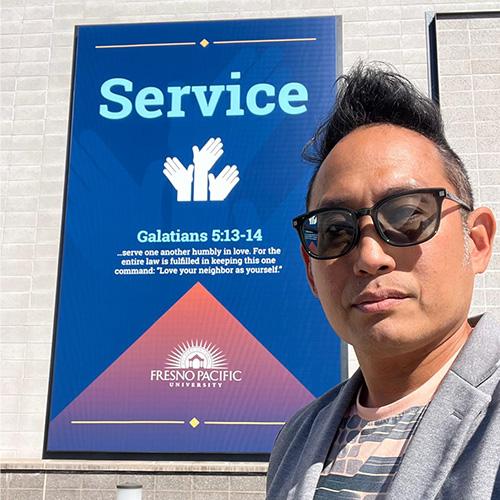Professor Lloyd Chia standing in front of a banner