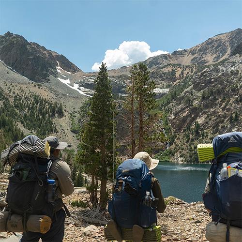 Backpacking group with mountains and lake in the background