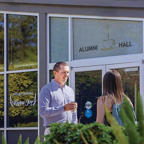 Man standing in front of Alumni Hall