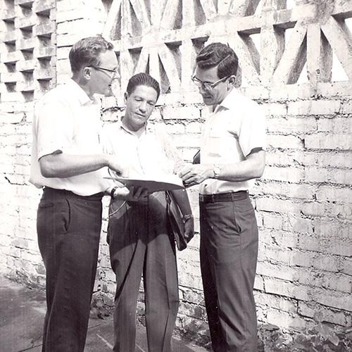 Vernon Reimer looking at a book with a group