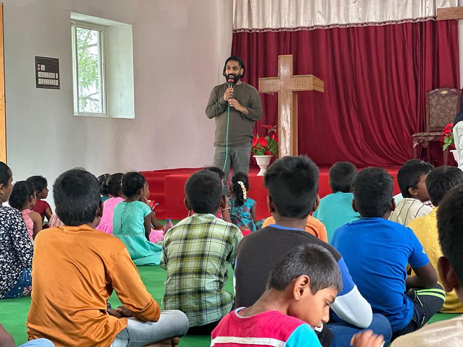 Sam Penderla in front of children, teaching.