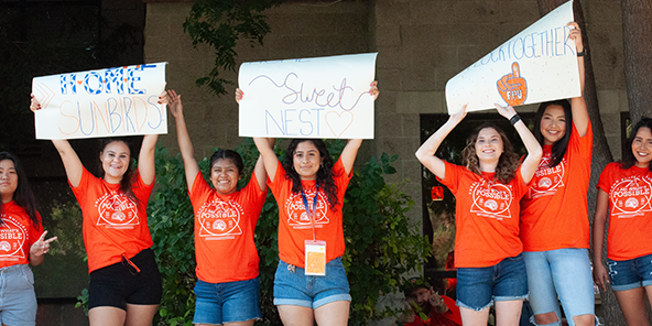 Photo of students holding up signs welcoming new students
