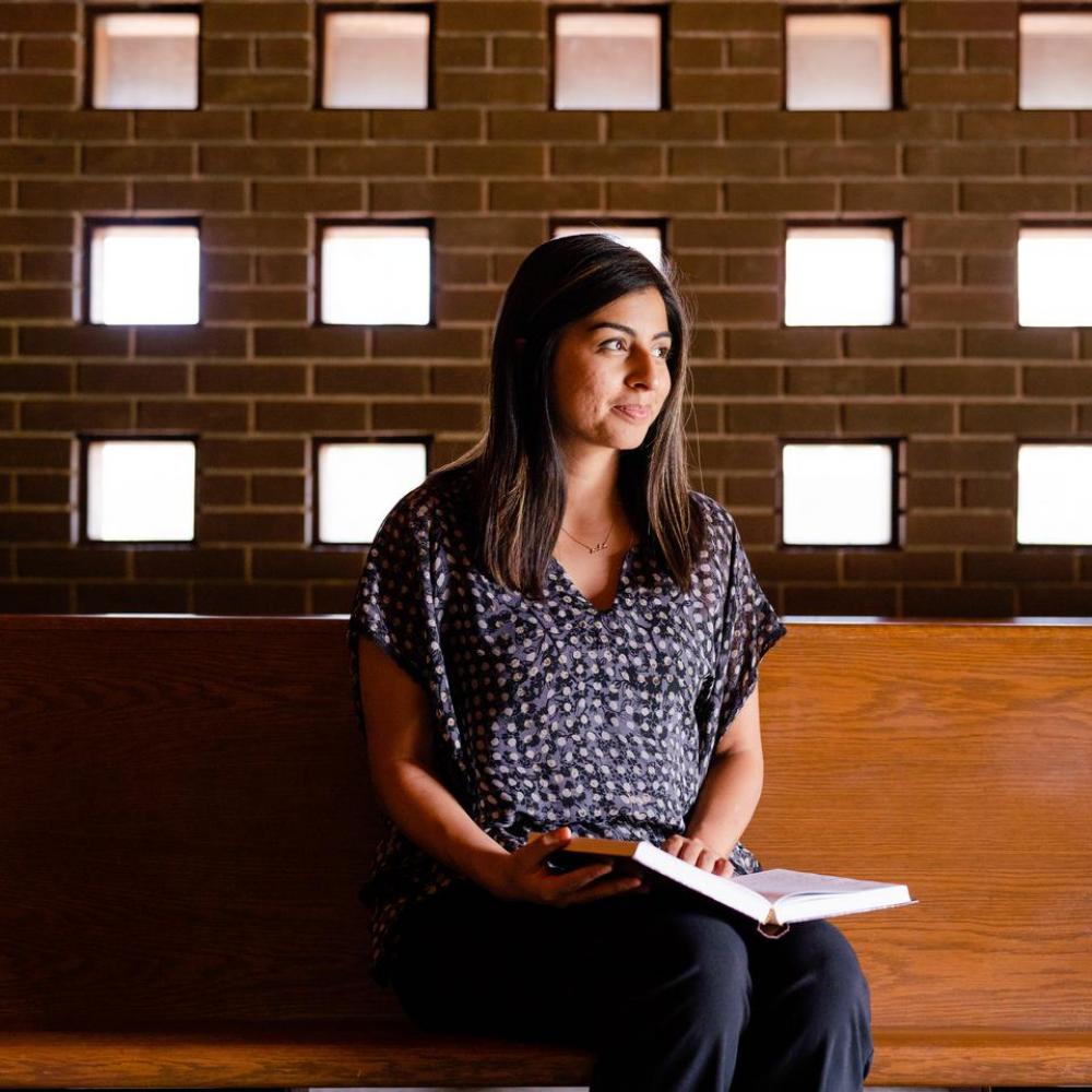Student sitting in the chapel with a bible