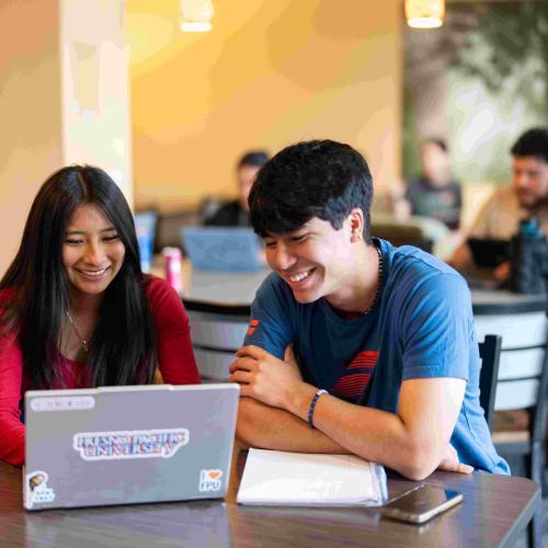 College students sitting at a table smiling
