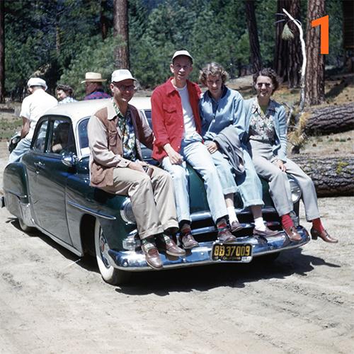 Photo of students sitting on a car.
