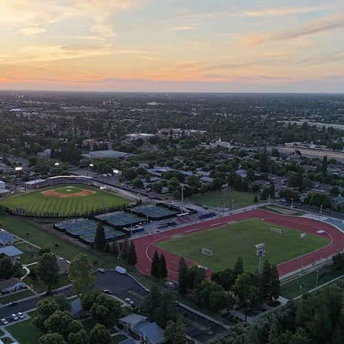 Aerial view of Fresno Pacific University’s baseball field, tennis courts and track at sunset.
