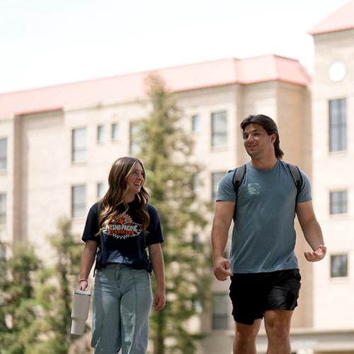 Image of two people walking on a college campus