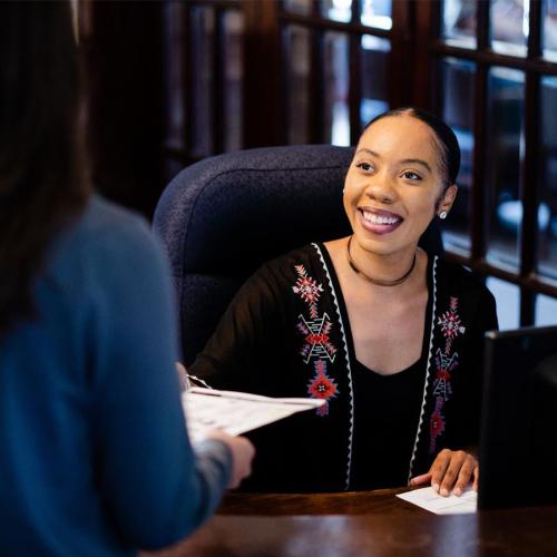 Seminary assistant helping someone with paperwork