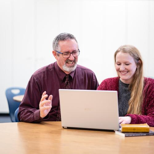 Professor helping a student on their computer