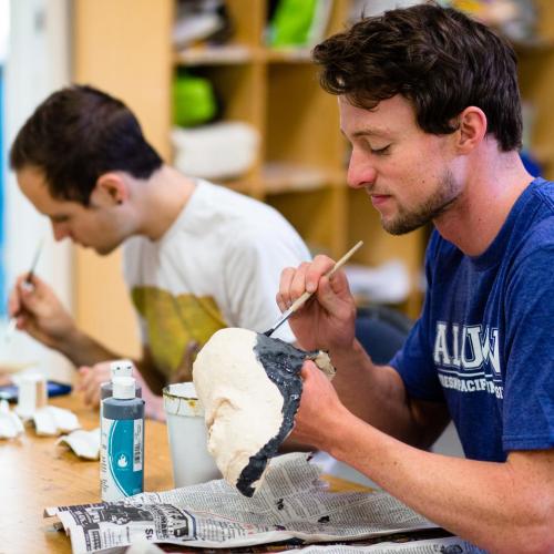 Photo a student with a blue shirt painting