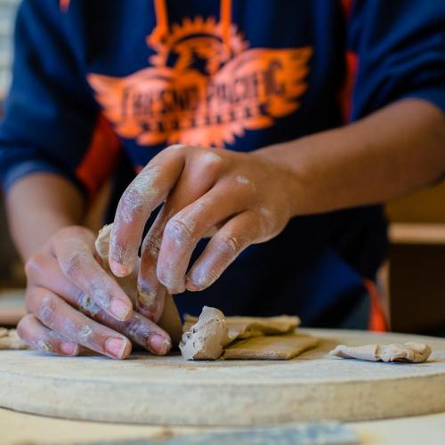 Closeup of student's hands working with clay