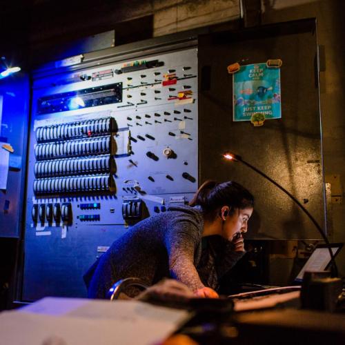 Student working with stage lighting control panel
