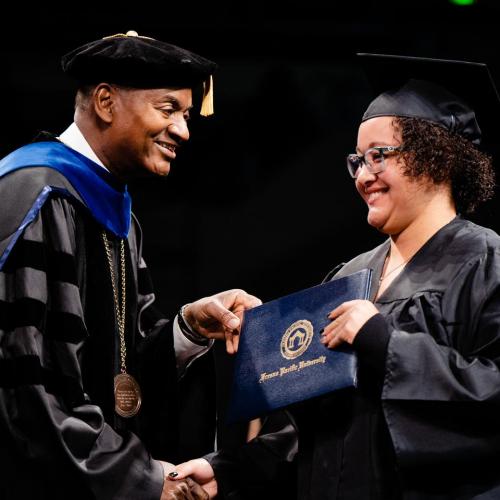 President Jones handing a diploma to an FPU graduate