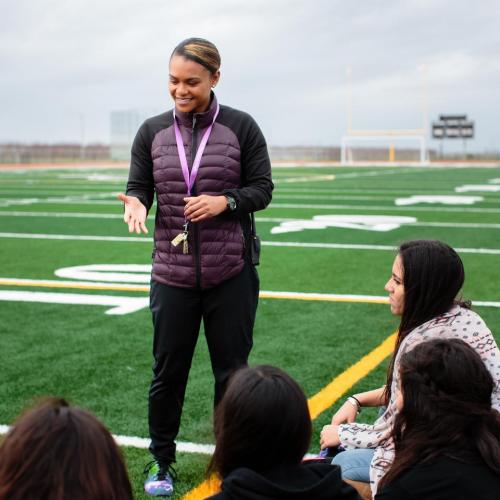 A coach with students on the field