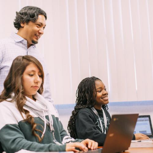 A grade school teacher helping students