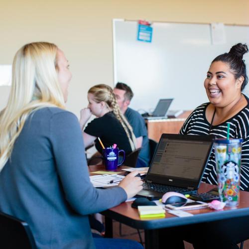 Student sitting across from a staff member, talking
