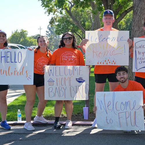 Students holding signs welcoming new students