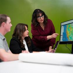 Professor pointing to monitor while students are sitting
