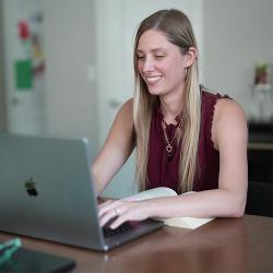 Photo of woman smiling using a laptop