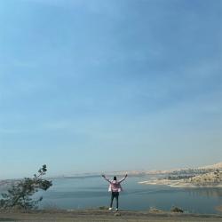 Image of figure lifting hands with a landscape in the background