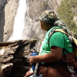 Student sitting while looking at a waterfall