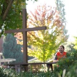 Cross in the Forest on FPU campus with man sitting at a picnic table