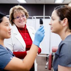 A nursing student demonstrating an eye examination