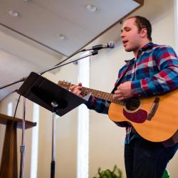 worship leader playing a guitar and singing