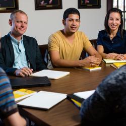 Students sitting at a table with a professor.