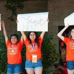 Photo of students holding up signs welcoming new students