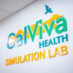 Colorful CalViva Health Simulation Lab sign mounted on a white wall.
