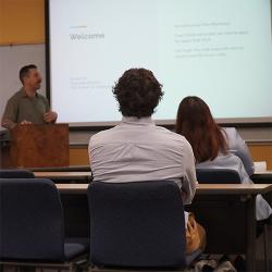 A man presents at a business workshop in a classroom.